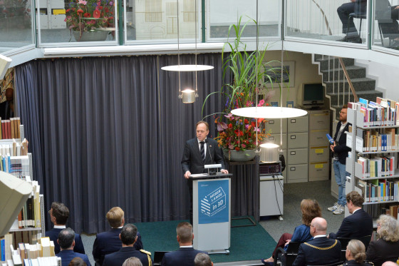 Zu sehen ist Prof. Dr. Jaco Pekelder am Rednerpult der gut besuchten Bibliothek im Haus der Niederlande.<address>© Uni MS - Brigitte Heeke</address>