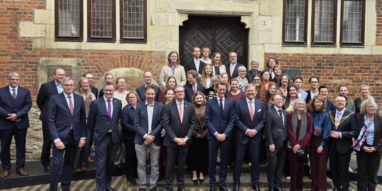 Vor dem Eingang des Krameramthauses stehen König Willem-Alexander (vorne, 6. v. r.) und Ministerpräsident Hendrik Wüst in einer Gruppe.<address>© Uni MS - Norbert Robers</address>