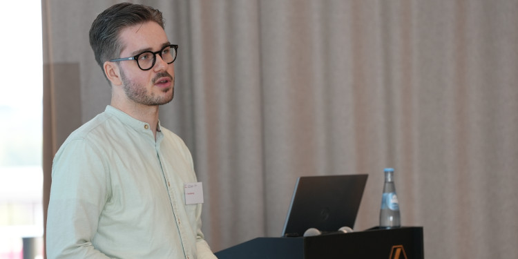 Das Bild zeigt Yannis Bermig bei einem Vortrag.<address>© Uni MS - Timo Adiek</address>