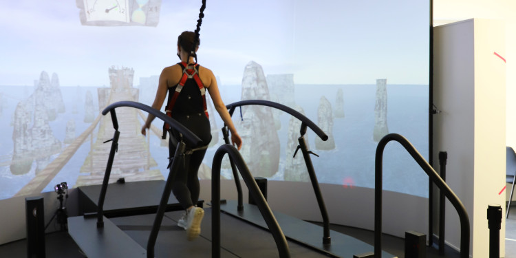 On the large-scale equipment called GRAIL (“Gait Real-time Analysis Interactive Lab) a test person on a treadmill walks through a virtual world. The equipment enables a detailed analysis of gait and freezing to be made.<address>© Neuromotor and Training Department - Robert Stojan</address>