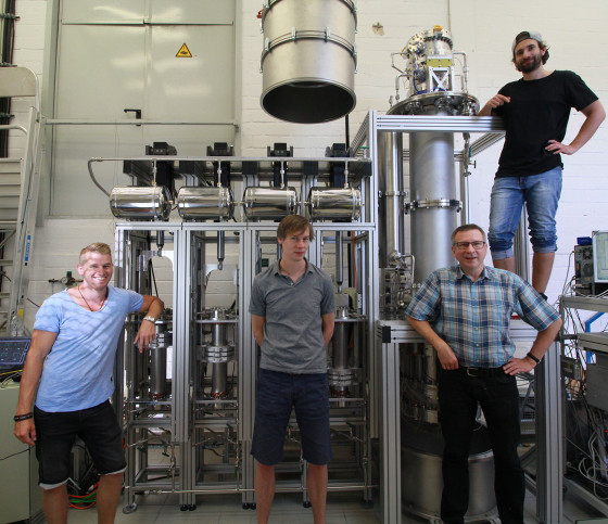 Das Foto zeigt Denny Schulte, Christian Huhmann, Christian Weinheimer und Michael Murra (v. l) mit dem Destillationssystem am Institut für Kernphysik der Universität Münster, bevor die Anlage ins Gran-Sasso-Untergrundlabor transportiert wurde.<address>© Simon Peters</address>