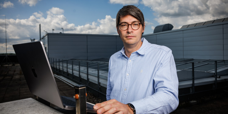 Benjamin Risse schaut in die Kamera. Er steht auf dem Dach des GEO-I-Gebäudes, vor ihm steht ein Laptop.<address>© Uni MS - Peter Leßmann</address>