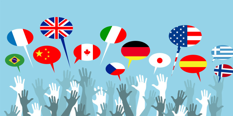 The illustrated symbolic photo shows hands with speech bubbles above them displaying various flags.<address>© stock.adobe.comm - xyz+</address>