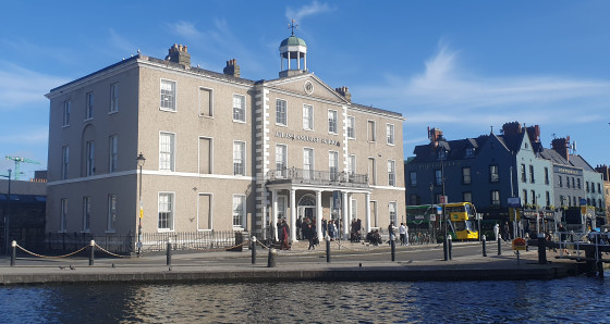 The picture shows the exterior of the language school building in Dublin, with a river in front of it.<address>© private</address>