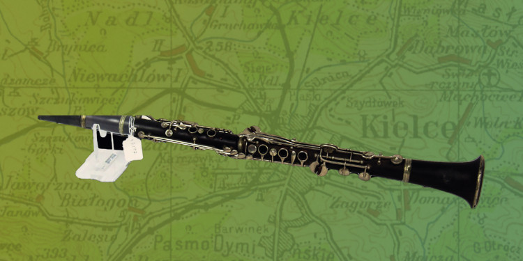 Zu sehen ist eine Klarinette vor einer grün eingefärbten polnischen Landkarte.<address>© NHM UK</address>