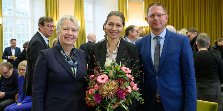 Zu sehen sind drei Personen - in der Mitte steht die künftige Rektorin der Universität Münster, Susanne Menzel-Riedl.<address>© Uni Münster - Michael C. Möller</address>