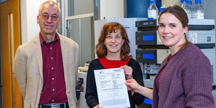 Das Bild zeigt Andreas Hensel, Martina Düfer und Katarina Kühn (von links) in einem Labor. Sie halten eine Patenturkunde in die Kamera.<address>© Uni MS - Linus Peikenkamp</address>