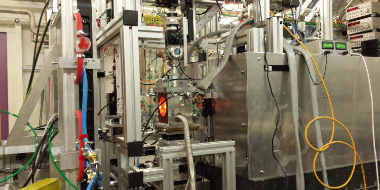 An overview of the experimental setup at DESY in Hamburg reveals the vacuum chamber housing the high-temperature diamond anvil cell. This is installed at the Extreme Conditions beamline. The cell&#039;s orange colour comes from the light it emits at high temperatures.<address>© Carmen Sánchez-Valle</address>
