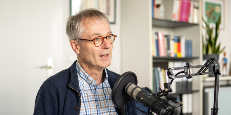 Das Foto zeigt den Theologen Professor Doktor Norbert Köster. Er spricht in ein Mikrofon.<address>© Uni MS - Linus Peikenkamp</address>