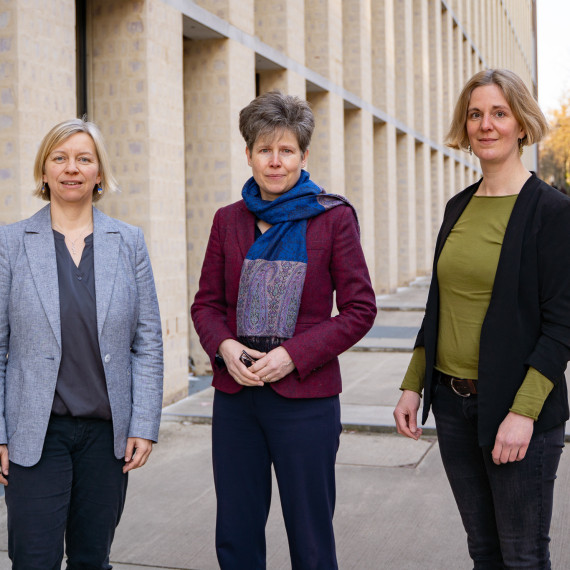 Regina Elsner, Ricarda Vulpius und Christina Clasmeier stehen vor dem Philosophikum und schauen in die Kamera.<address>&copy; Uni MS - Linus Peikenkamp</address>