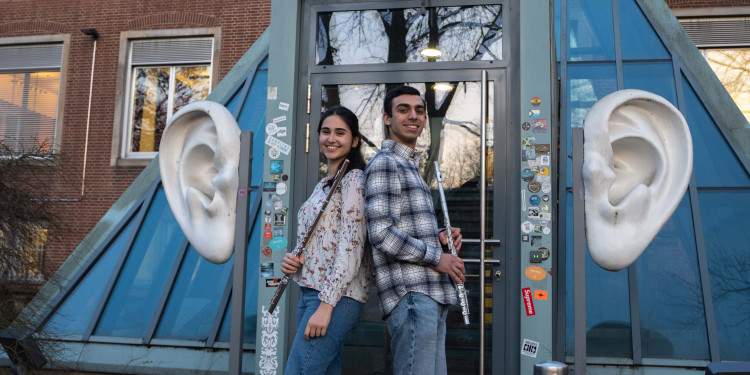 Zu sehen sind die Studentin Shaya Eldar (links) und der Student Elnur Misirli vor dem Portal der Musikhochschule.<address>&copy; Uni MS - Brigitte Heeke</address>