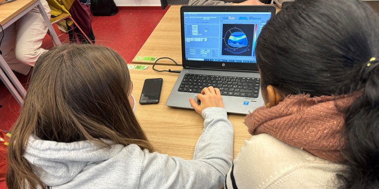 Zwei Schülerinnen (von hinten fotografiert) sitzen vor einem Laptop, auf dem Bildschirm ist eine Tomographieaufnahme zu erkennen<address>&copy; Uni MS - David Borgelt</address>