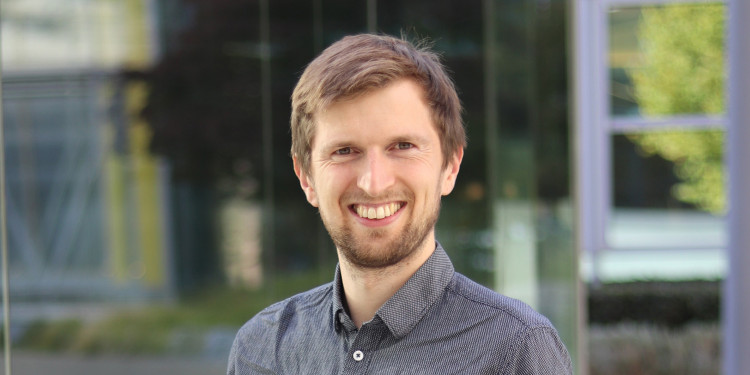 Dr. Thomas Seidel im Porträt (Brustporträt; aufgenommen draußen vor einem Gebäude, das unscharf im Hintergrund ist)<address>&copy; privat</address>