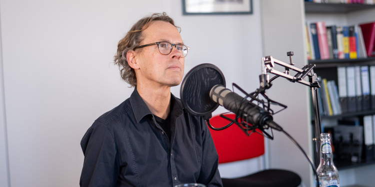 Das Foto zeigt den Evolutionsbiologen Professor Doktor Joachim Kurtz. Er sitzt vor einem Mikrofon.<address>&copy; Uni MS - Linus Peikenkamp</address>