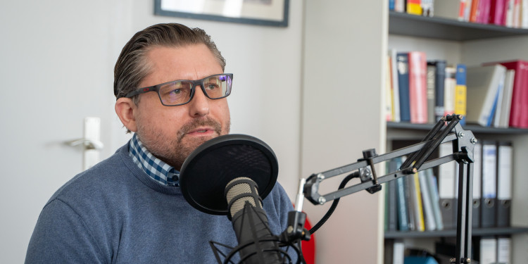 Das Foto zeigt Professor Doktor Patrick Sänger. Er spricht in ein Mikrofon.<address>&copy; Uni MS - Linus Peikenkamp</address>