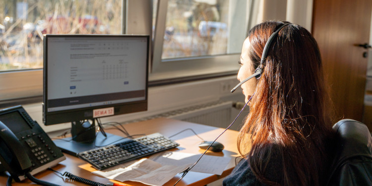 Die Studentin Sabrin sitzt vor einem PC-Monitor, sie spricht in ein Headset und tippt ihre Antworten in ein Umfrageformular.<address>&copy; Uni MS - Linus Peikenkamp</address>