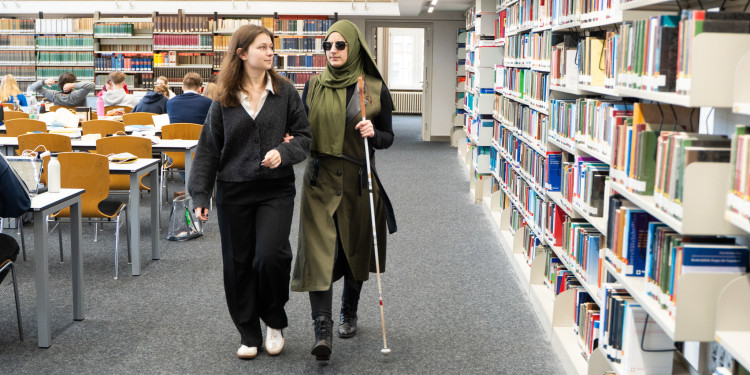 Kübranur Binek (rechts) und Madita Laumen sind in der Bibliothek des rechtswissenschaftlichen Seminars zu sehen.<address>&copy; Uni MS - Linus Peikenkamp</address>