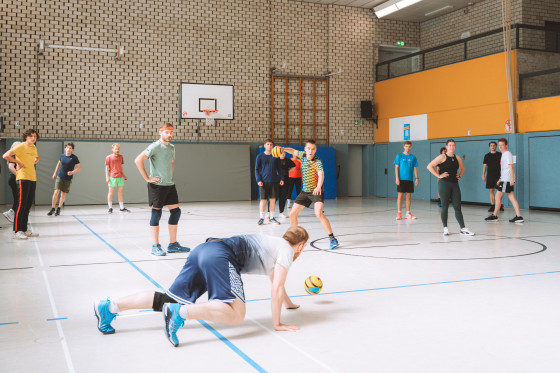 Das Bild zeigt etwa zehn Sportlerinnen und Sportler in einer Turnhalle beim Völkerball.<address>&copy; Hochschulsport</address>