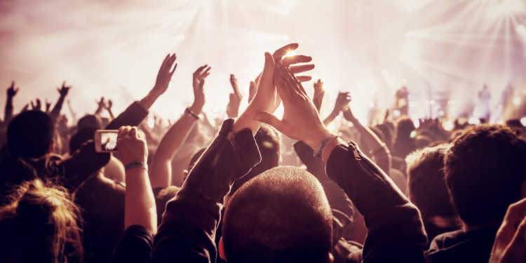 The picture shows people clapping their hands at a concert.<address>&copy; stock.adobe.com - Anna Om</address>