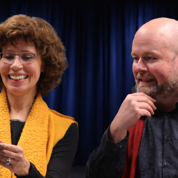 Es sind eine Frau und ein Mann zu sehen. Sie schauen auf einen Notizzettel und lachen.<address>&copy; Daniela Sicken</address>