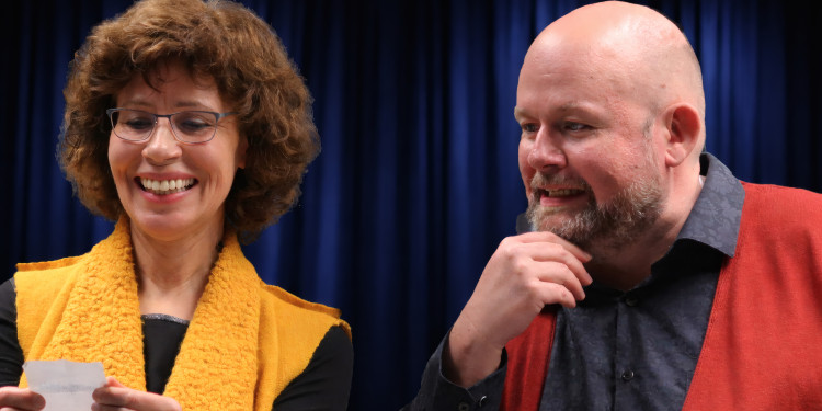 Es sind eine Frau und ein Mann zu sehen. Sie schauen auf einen Notizzettel und lachen.<address>&copy; Daniela Sicken</address>