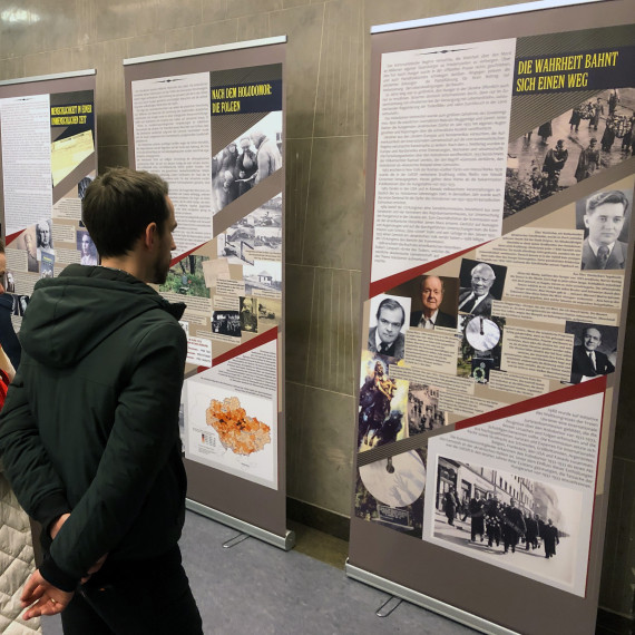 Drei Menschen stehen im Gebäue der Ludwig-Maximilians-Universität München vor den Stellwänden der Ausstellung „Wieso seid ihr noch am Leben?“.<address>&copy; LMU München - Gerhard Gnauck</address>