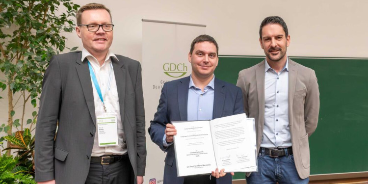 v. l.: Prof. Dr. Chistian Ducho (GDCh), Prof. Marcel Bermúdez, Dr. Chistian Kuttruff (GDCh) bei der Preisübergabe; Marcel Bermúdez hat eine Urkunde in den Händen<address>&copy; Uni MS – Peter Dziemba</address>