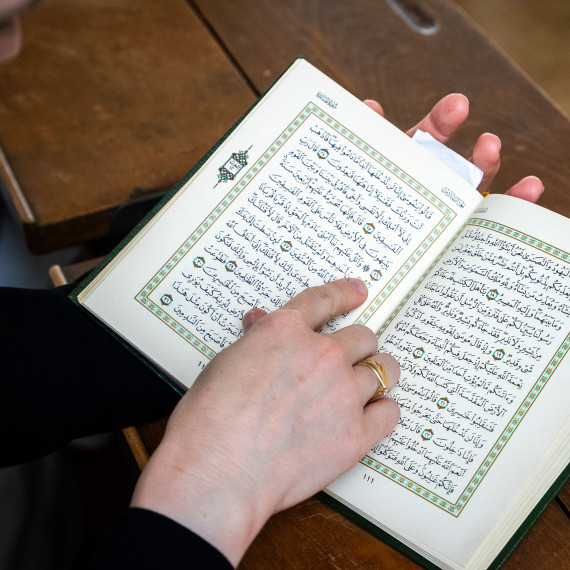Eine Frau hält einen aufgeschlagenden Koran in der Hand.<address>&copy; Uni MS - Linus Peikenkamp</address>
