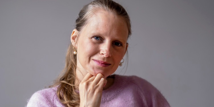 Rosa Coco Schinagl, die Autorin der Arbeit. Sie trägt ihre bloden Haare zum Zopf, der auf ihren violetten Pullover fällt. Sie lächelt in die Kamera.<address>&copy; privat</address>