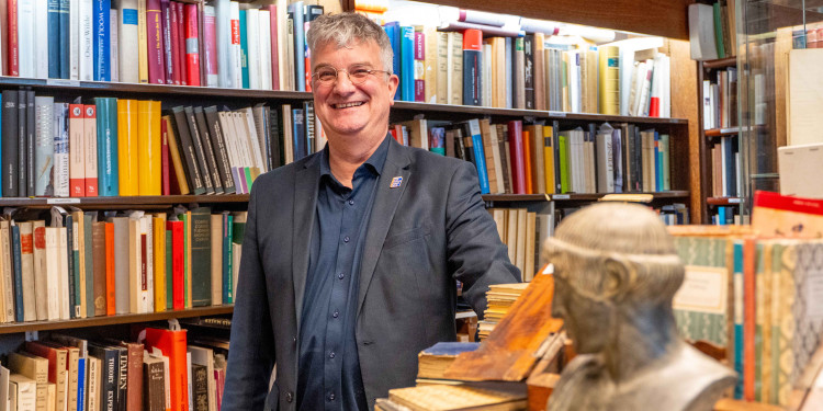Das Bild zeigt Michael Solder in seinem Antiquariat zwischen Bücherreihen.<address>&copy; Uni MS - Linus Peikenkamp</address>