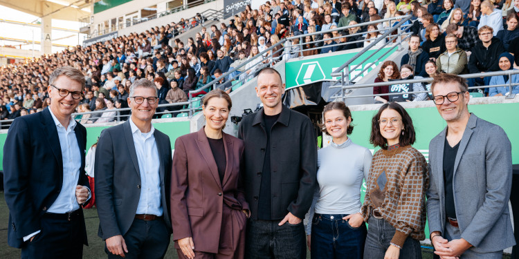 Mit zahlreichen Partnern begrüßten Rektorin Prof. Dr. Susanne Menzel-Riedl (3.v.l.), Oberbürgermeister Tilman Fuchs (2.v.l.) und Ole Kittner (M.) vom SC Preußen Münster rund 4000 Erstsemester auf den Tribünen.<address>&copy; Uni MS – Christoph Steinweg</address>