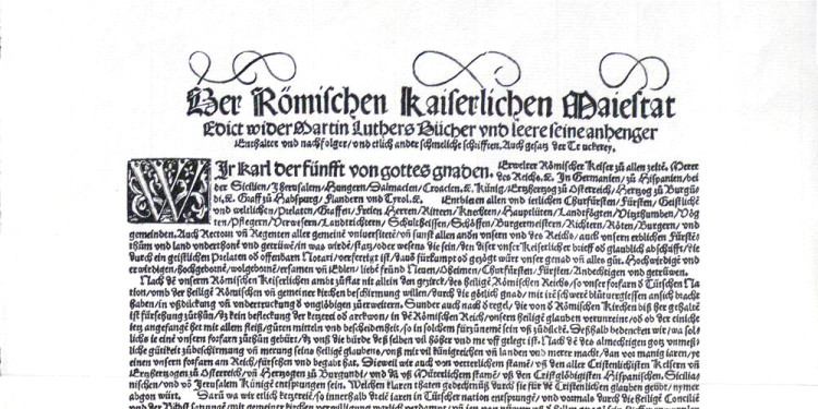 Zu sehen ist der obere Abschnitt eines Facsimile nach dem Original-Plakatdruck in der Lutherabteilung der Stadtbibliothek Worms. Er zeigt den Text des Wormser Edikts.<address>&copy; Altertumsverein Worms/ dilibri.de</address>